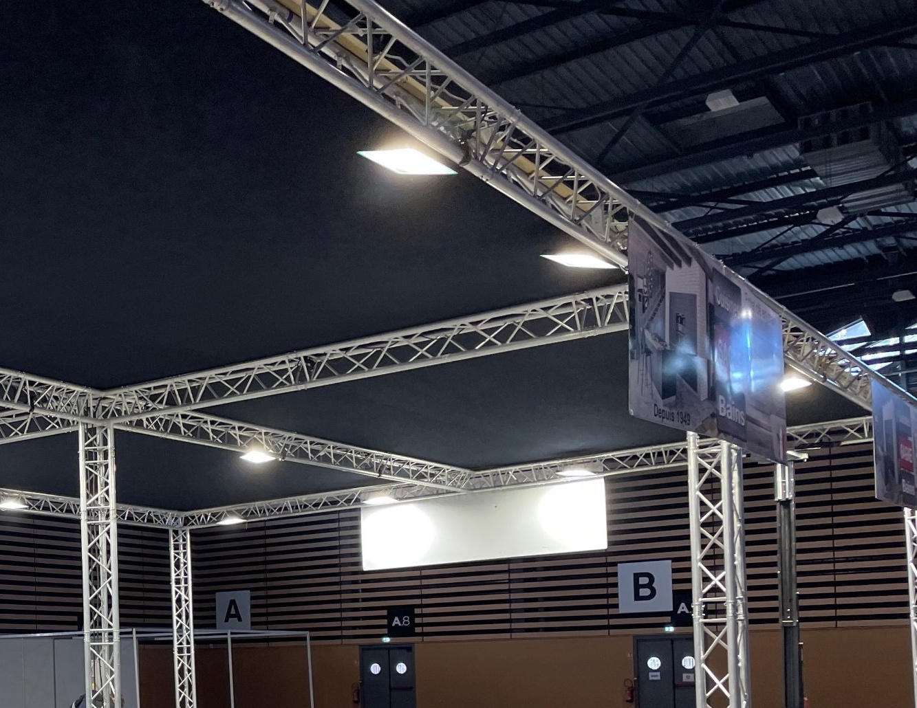 Structure en aluminium avec plafond tendu en velum noir et éclairage LED sur un salon professionnel
