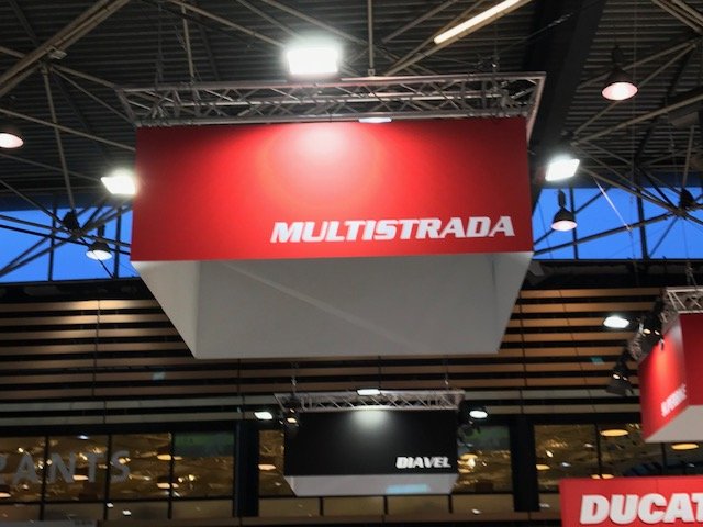 Cadres en structure suspendus au-dessus d'un stand avec habillage textile de marque